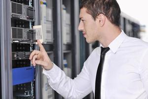 young engeneer in datacenter server room photo