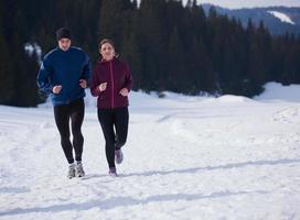 pareja trotando afuera en la nieve foto