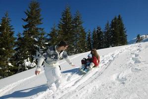 family having fun on fresh snow at winter photo