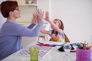 Mother and little daughter  playing together  drawing creative artwork photo