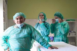 retrato de médicos uniformados y preparándose para realizar una operación quirúrgica en el teatro del hospital. concepto médico. foto