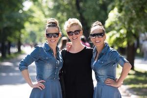 portrait of three young beautiful woman with sunglasses photo