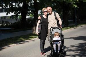 couple with baby pram in summer park photo