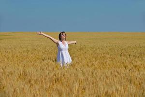 mujer joven en campo de trigo en verano foto