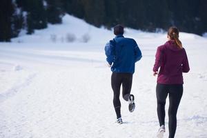 pareja trotando afuera en la nieve foto