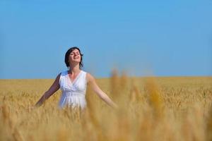 young woman in wheat field at summer photo