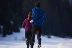 pareja trotando afuera en la nieve foto