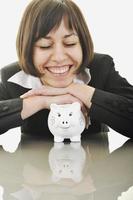 business woman putting coins money in piggy bank photo