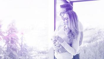 young couple enjoying morning coffee by the window photo