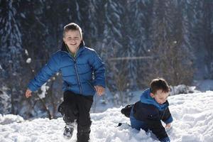 niños jugando con nieve fresca foto