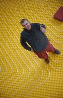 workers installing underfloor heating system photo