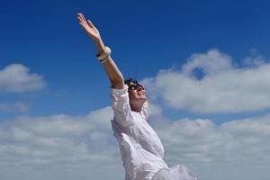 happy young woman with spreading arms to sky photo