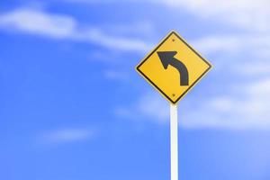 Traffic sign left Uturn sign on cement pole beside the rural road with white cloudy bluesky background copy space photo