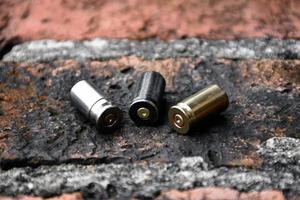 9mm pistol bullets and bullet shells on brick floor, soft and selectivec focus. photo