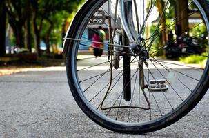 vista de cerca de la llanta pinchada trasera de una bicicleta antigua que estacionó en el pavimento al lado de la carretera. enfoque suave y selectivo. foto