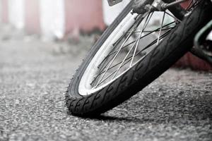 Closeup view of rear flat tire of vintage bicycle which parked on pavement beside the road. soft and selective focus. photo