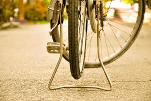 vista de cerca de la llanta pinchada trasera de una bicicleta antigua que estacionó en el pavimento al lado de la carretera. enfoque suave y selectivo. foto