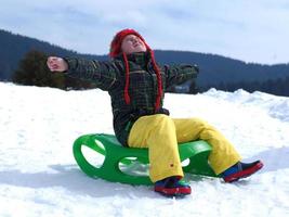 niño feliz divertirse en vacaciones de invierno en nieve fresca foto