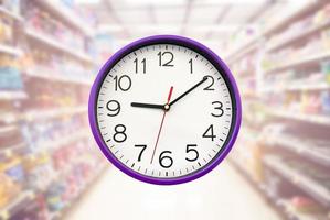 Analog clock on blurred supermarket background. photo