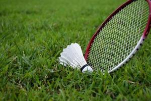 Badminton racket and badminton shuttlecock against cloudy and bluesky background, outdoor badminton playing concept. selective focus on racket. photo