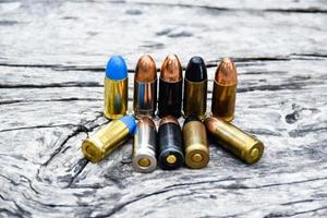 9mm pistol bullets and bullet shells on wooden table, soft and selectivec focus. photo