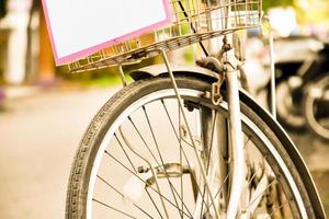 Closeup view of rear flat tire of vintage bicycle which parked on pavement beside the road. soft and selective focus. photo