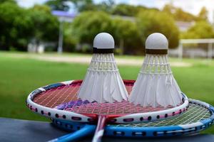 Badminton outdoors equipments white and yellow plastic shuttlecocks and badminton rackets, on grasslawn, soft and selective focus on shuttlecocks outdoor badminton playing concept photo