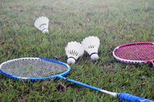 raqueta de bádminton y volante de bádminton contra un fondo nublado y azul, concepto de juego de bádminton al aire libre. enfoque selectivo en la raqueta. foto