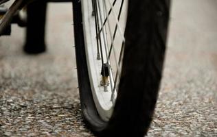 Closeup view of rear flat tire of vintage bicycle which parked on pavement beside the road. soft and selective focus. photo