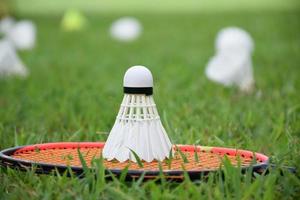 raqueta de bádminton y volante de bádminton contra un fondo nublado y azul, concepto de juego de bádminton al aire libre. enfoque selectivo en la raqueta. foto