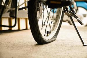 Closeup view of rear flat tire of vintage bicycle which parked on pavement beside the road. soft and selective focus. photo