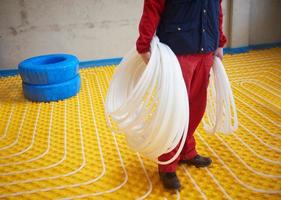 workers installing underfloor heating system photo