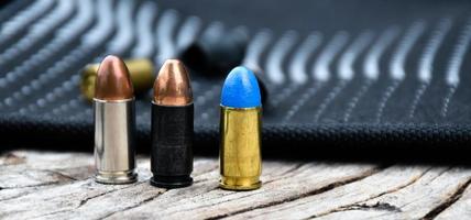 9mm pistol bullets and bullet shells on black leather background, soft and selectivec focus. photo