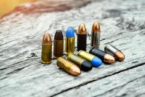 9mm pistol bullets and bullet shells on wooden table, soft and selectivec focus. photo