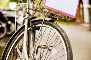 Closeup view of rear flat tire of vintage bicycle which parked on pavement beside the road. soft and selective focus. photo