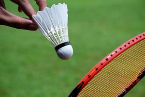 raqueta de bádminton y volante de bádminton contra un fondo nublado y azul, concepto de juego de bádminton al aire libre. enfoque selectivo en la raqueta. foto