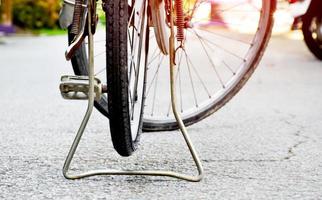 vista de cerca de la llanta pinchada trasera de una bicicleta antigua que estacionó en el pavimento al lado de la carretera. enfoque suave y selectivo. foto