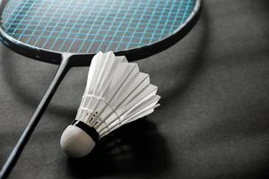 Badminton racket and badminton shuttlecock against cloudy and bluesky background, outdoor badminton playing concept. selective focus on racket. photo