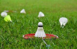 raqueta de bádminton y volante de bádminton contra un fondo nublado y azul, concepto de juego de bádminton al aire libre. enfoque selectivo en la raqueta. foto