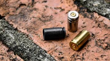 9mm pistol bullets and bullet shells on brick floor, soft and selectivec focus. photo