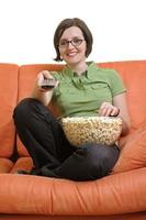 young woman eat popcorn and watching tv photo