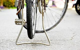 vista de cerca de la llanta pinchada trasera de una bicicleta antigua que estacionó en el pavimento al lado de la carretera. enfoque suave y selectivo. foto