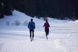 pareja trotando afuera en la nieve foto