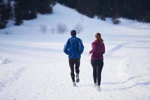 pareja trotando afuera en la nieve foto