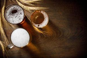 tres vasos de cerveza ligera con trigo en el mostrador del bar, copia espacio para tu texto foto