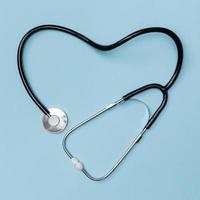 Stethoscope in shape of heart on blue table background, Good health from Doctor concept, Top view with Isolated on blue photo