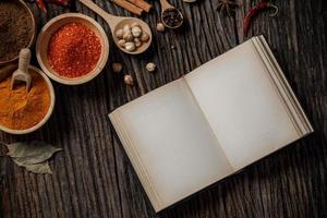 Herbs and spices and the book top view with copy space on the wooden table photo