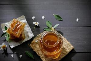 miel orgánica y panal en la mesa de madera, productos saludables por concepto de ingredientes naturales orgánicos foto