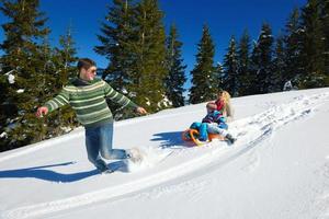 family having fun on fresh snow at winter photo