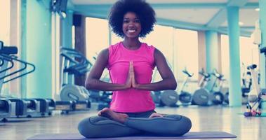 mujer de espalda en un gimnasio estirando y calentando foto